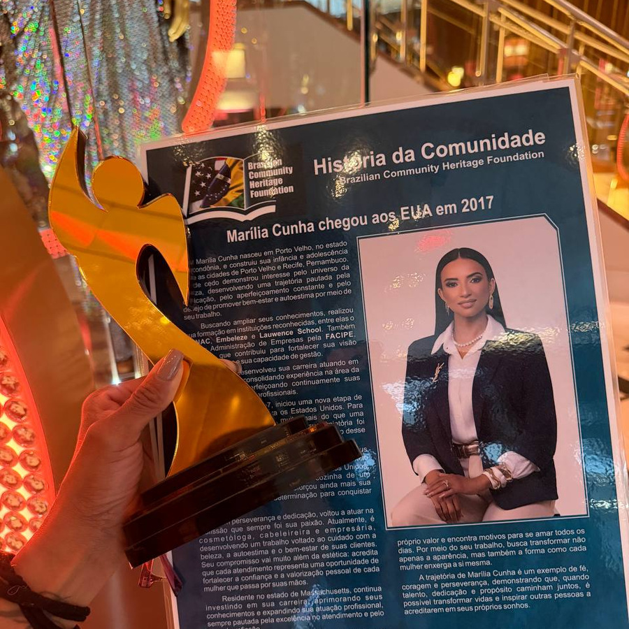 Trof&eacute;u e placa da Brazilian Community Heritage Foundation nas m&atilde;os de Mar&iacute;lia Cunha